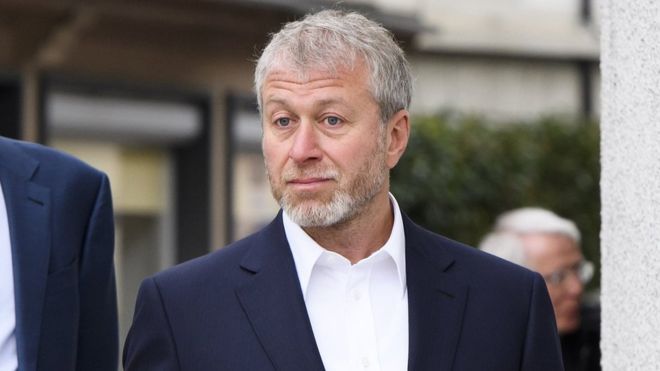 Roman Abramovich olhando para frente com um paletó preto e camisa branca